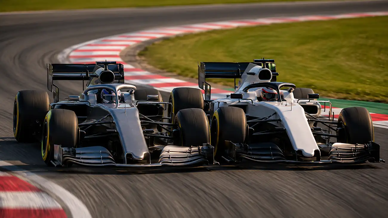 Due piloti di Formula 1 ruota a ruota in piena curva durante un duello in gara